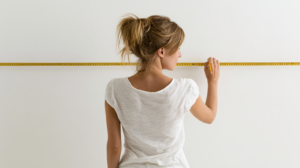 woman measuring wall